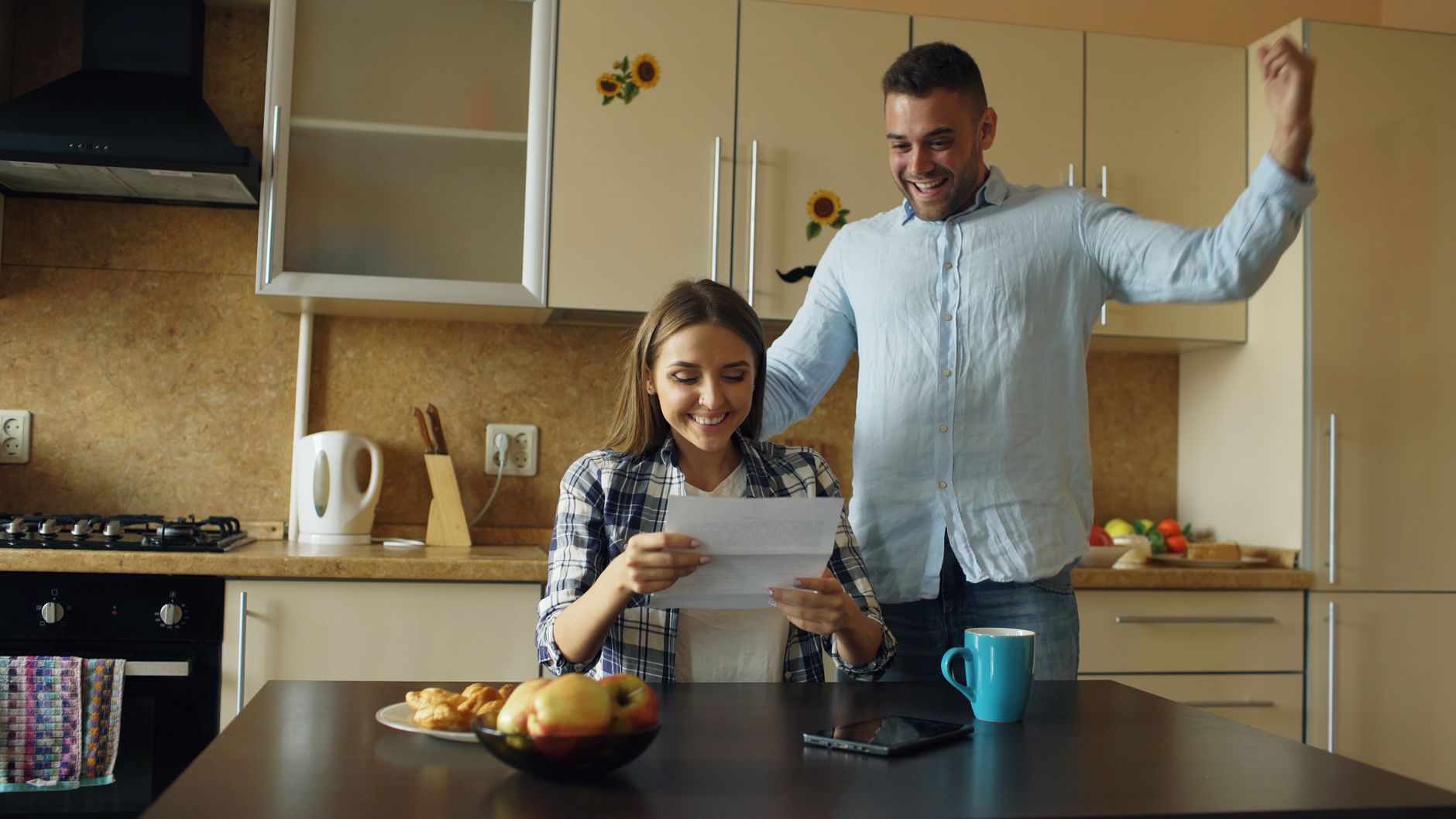 Person reading an insurance renewal notice at the kitchen table