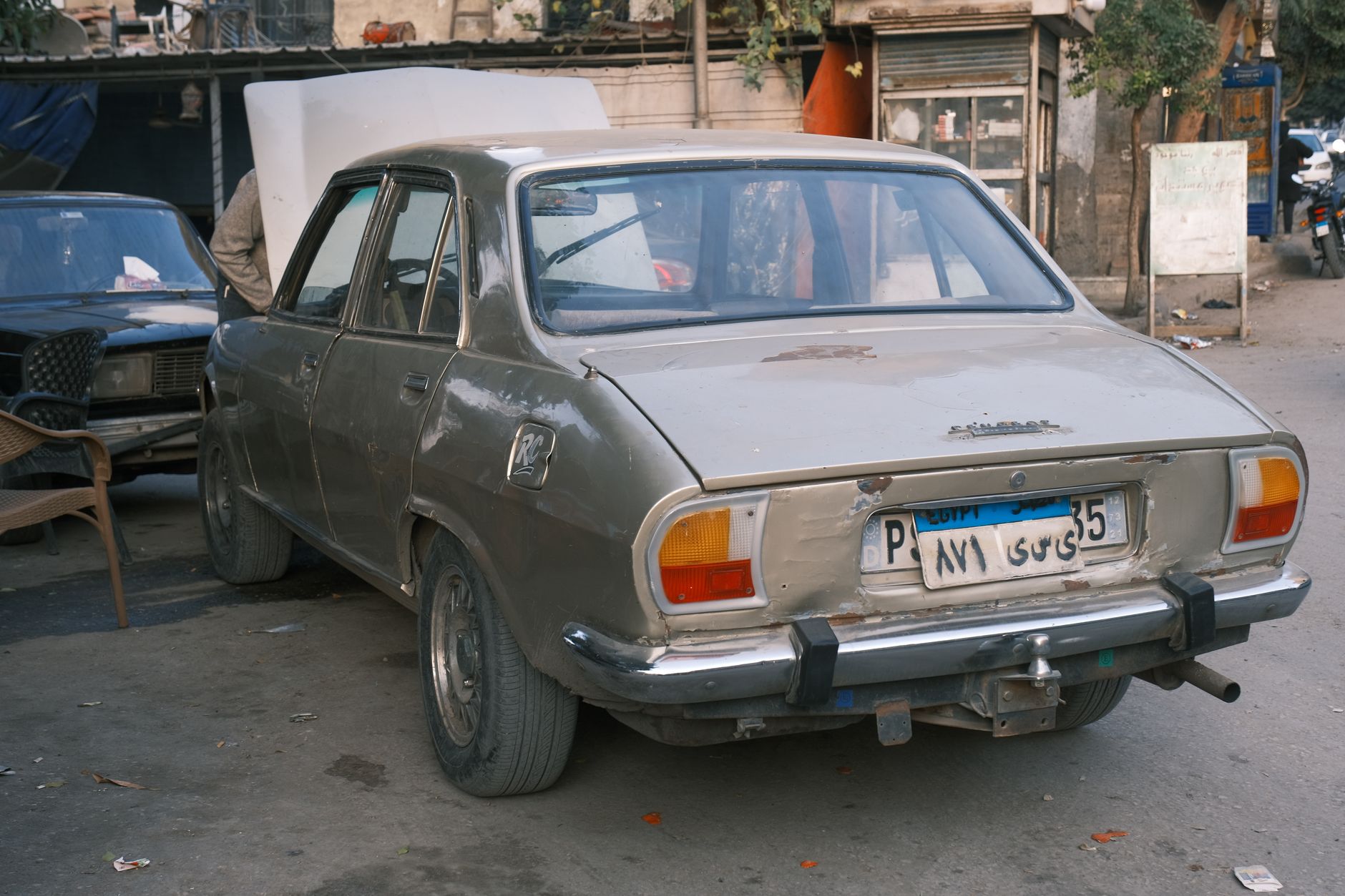 Older used car parked on a residential street, the kind where collision coverage may not pay off