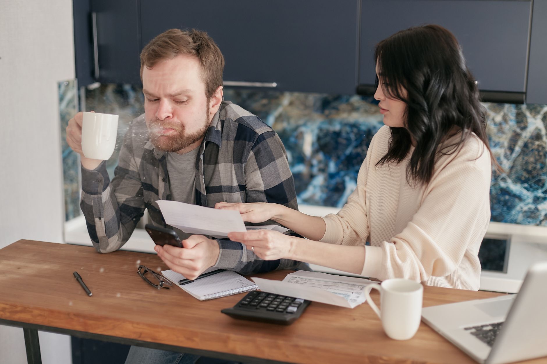 Couple going over a store card statement and payment plan at their kitchen table