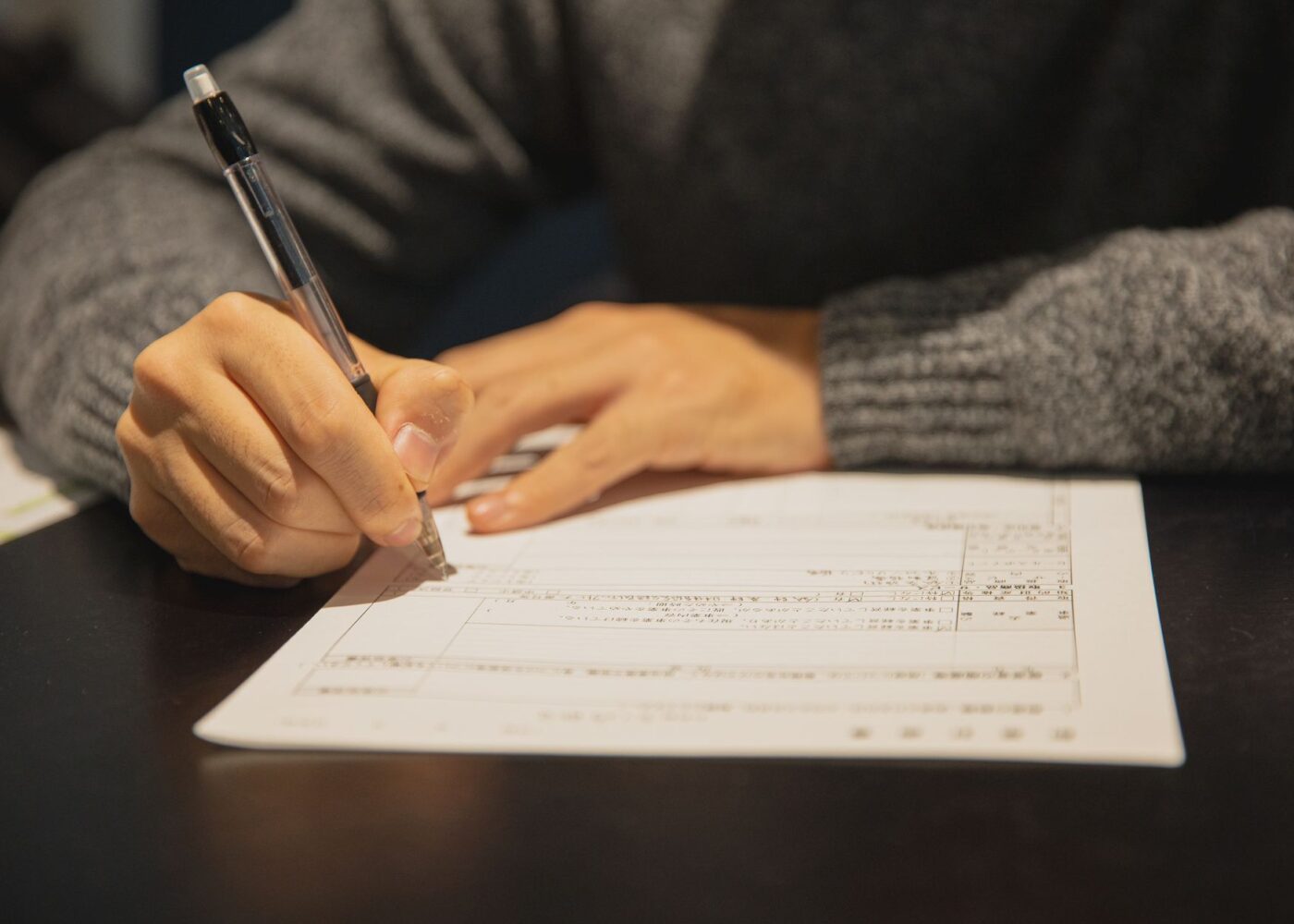 Recent college graduate filling out new-hire paperwork, including a W-4, on the first day of a job