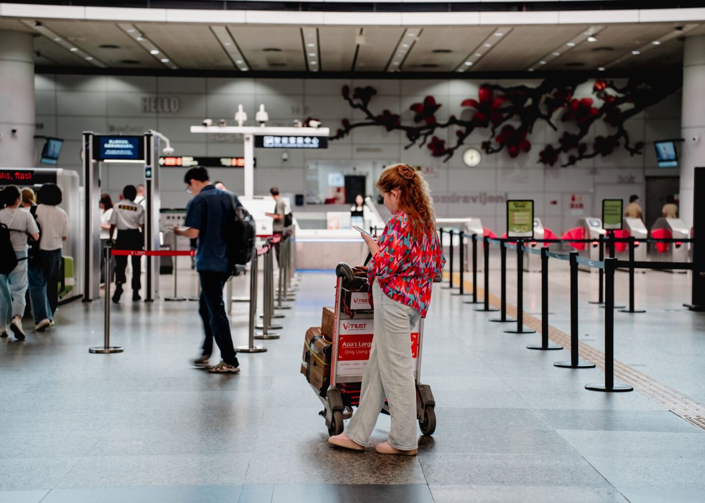 Family with suitcases checking bags at an airline counter before a summer vacation