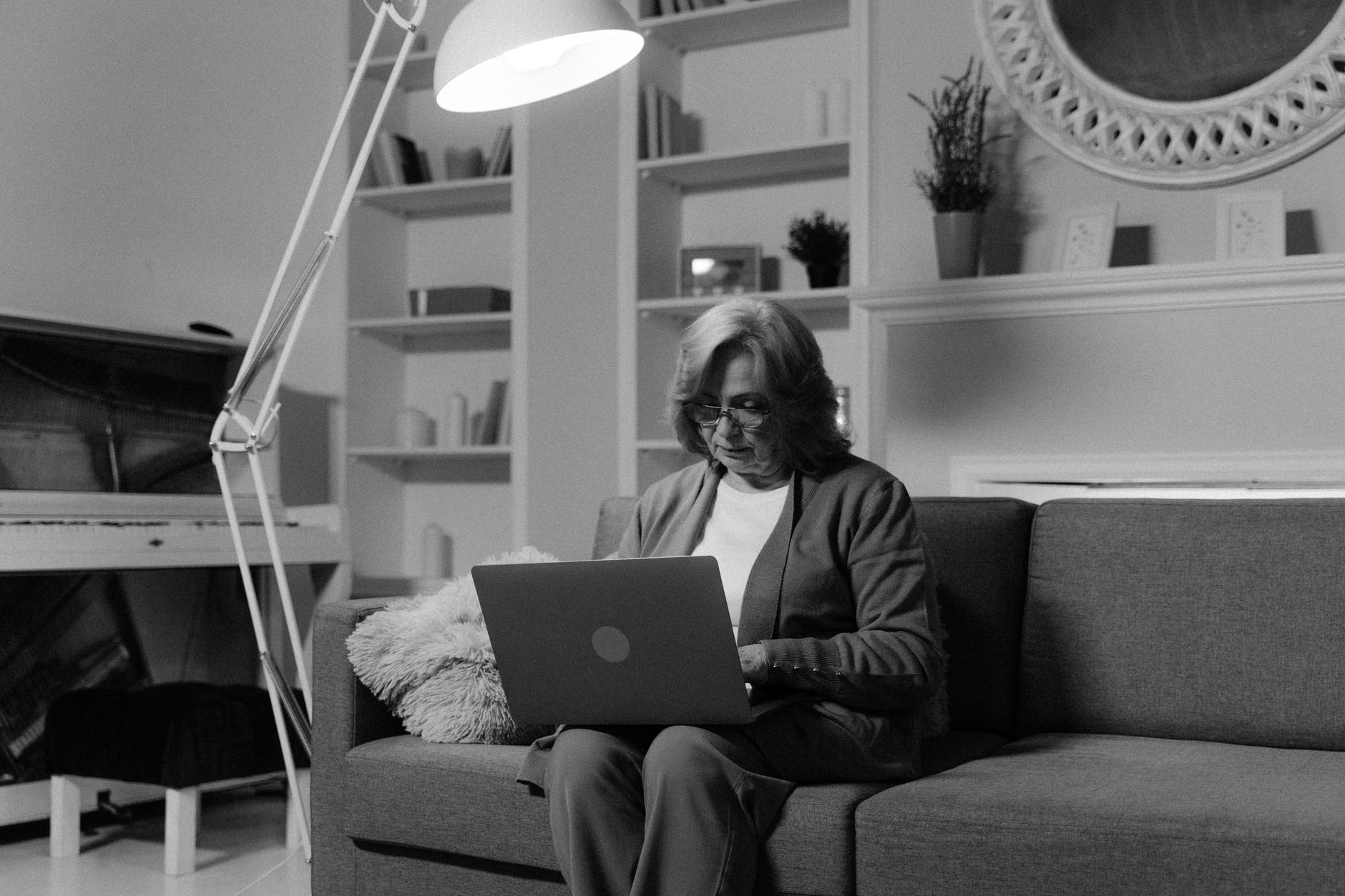 Older woman comparing Medicare drug plans on a laptop in her living room