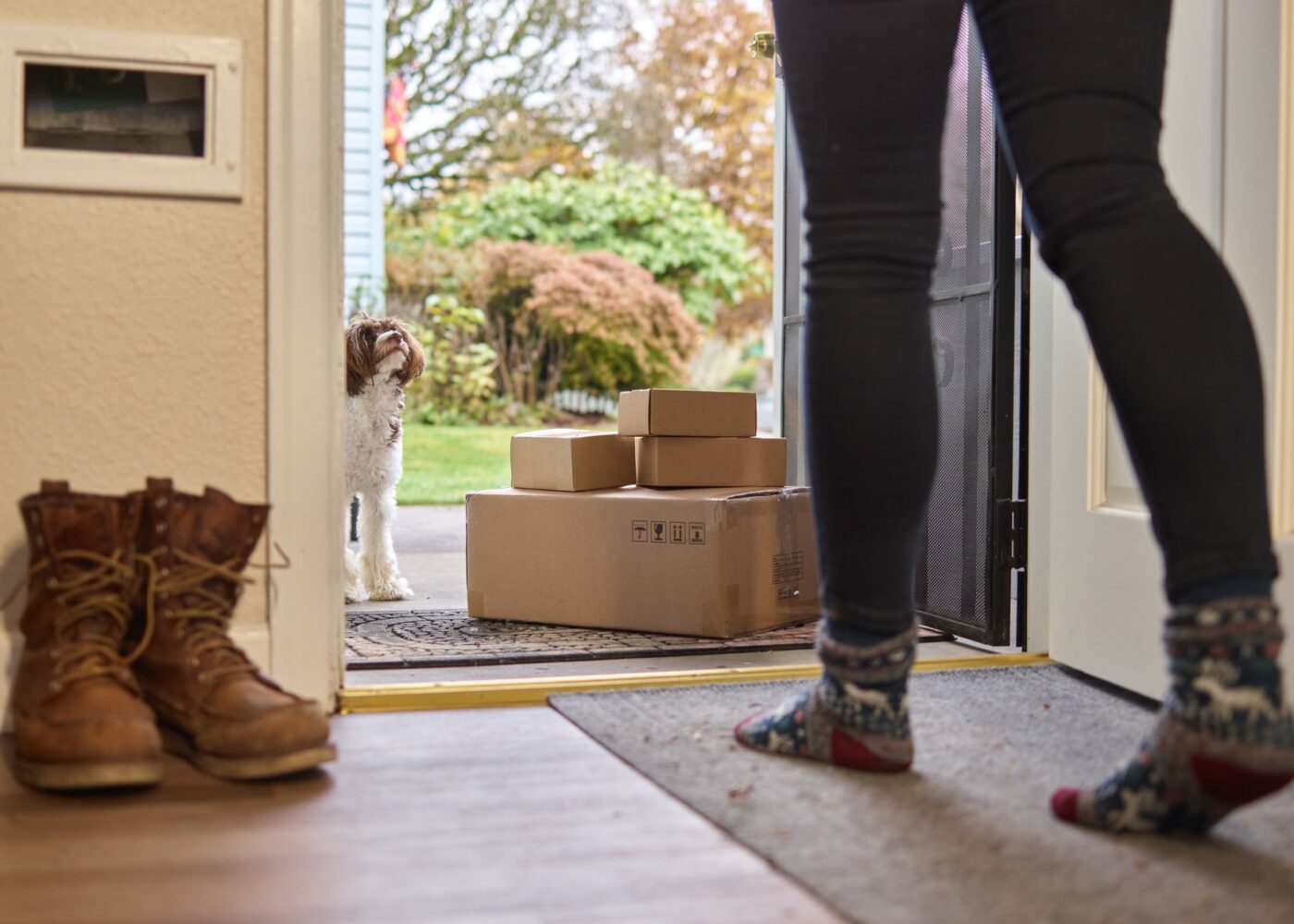 Woman sorting through unopened delivery boxes at home after a big online sale