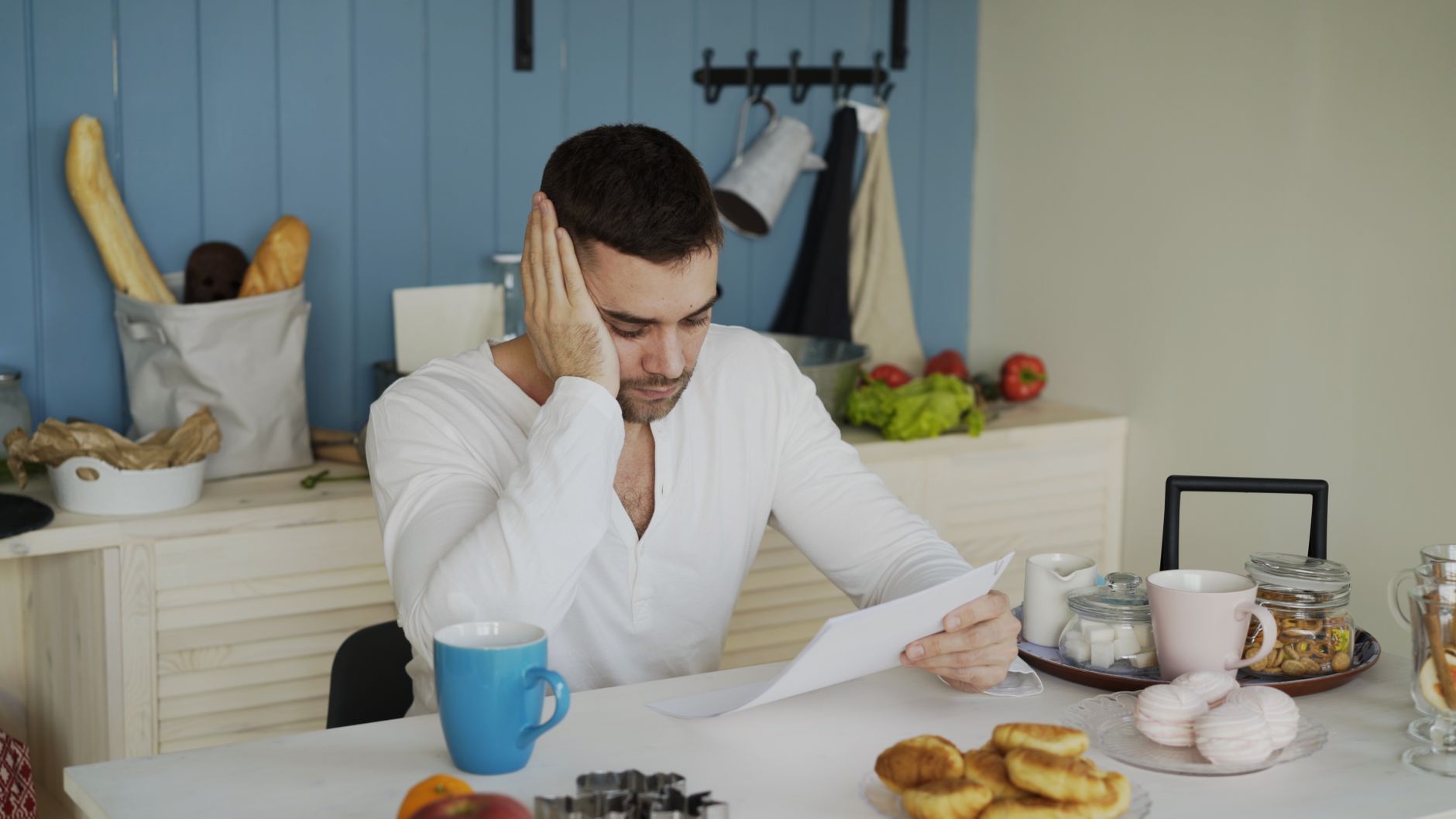 Man reading a heating fuel contract at his kitchen table before signing
