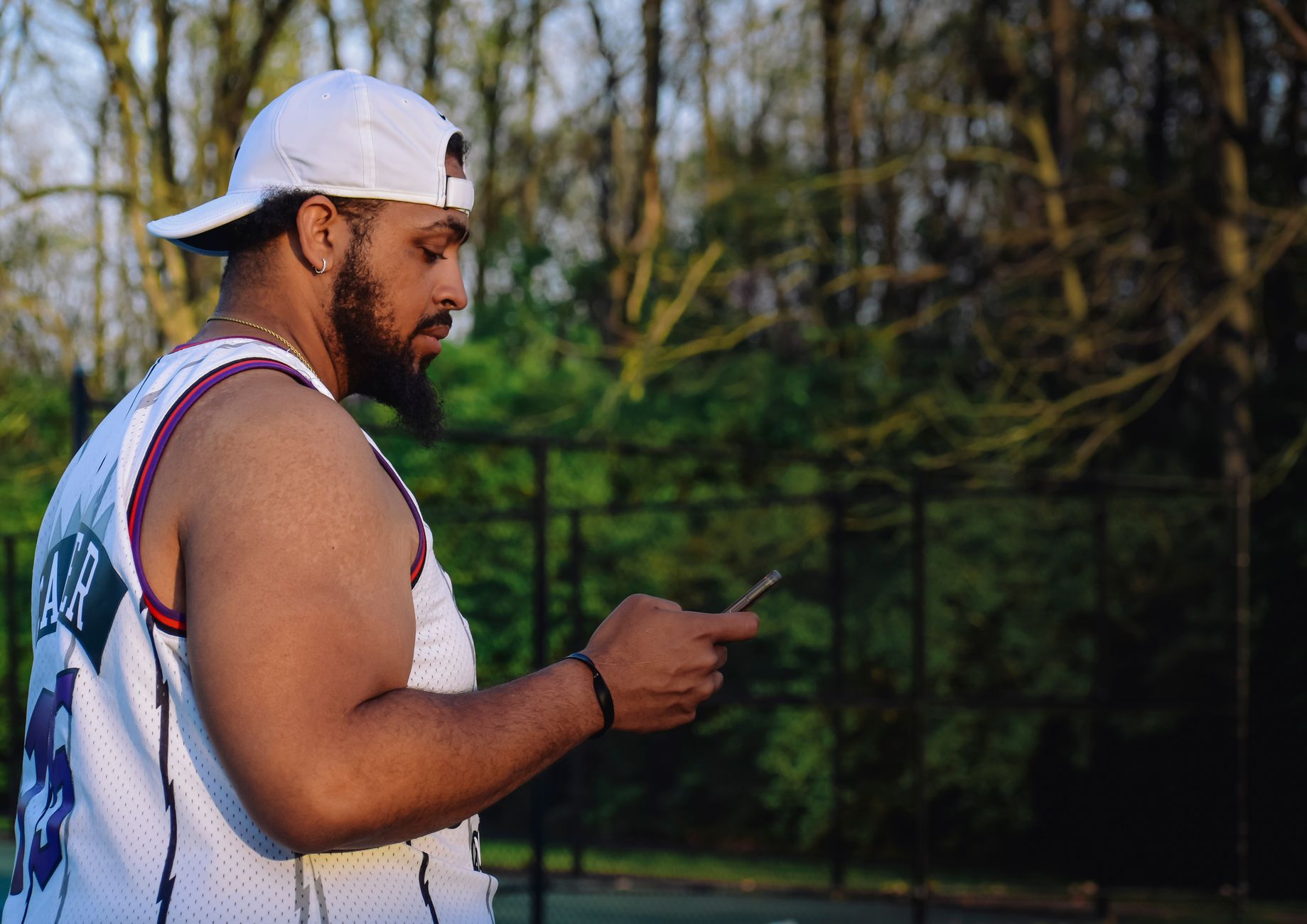 A bettor checks a multi-leg parlay ticket on his phone during a college basketball game