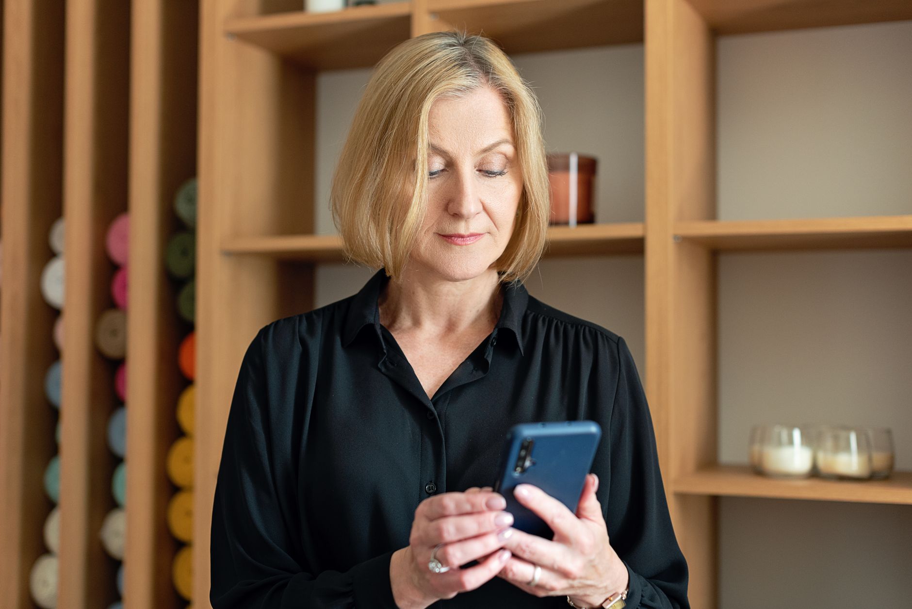 Woman reading a subscription price-change email on her phone, the notice California's auto-renewal law requires before a hike