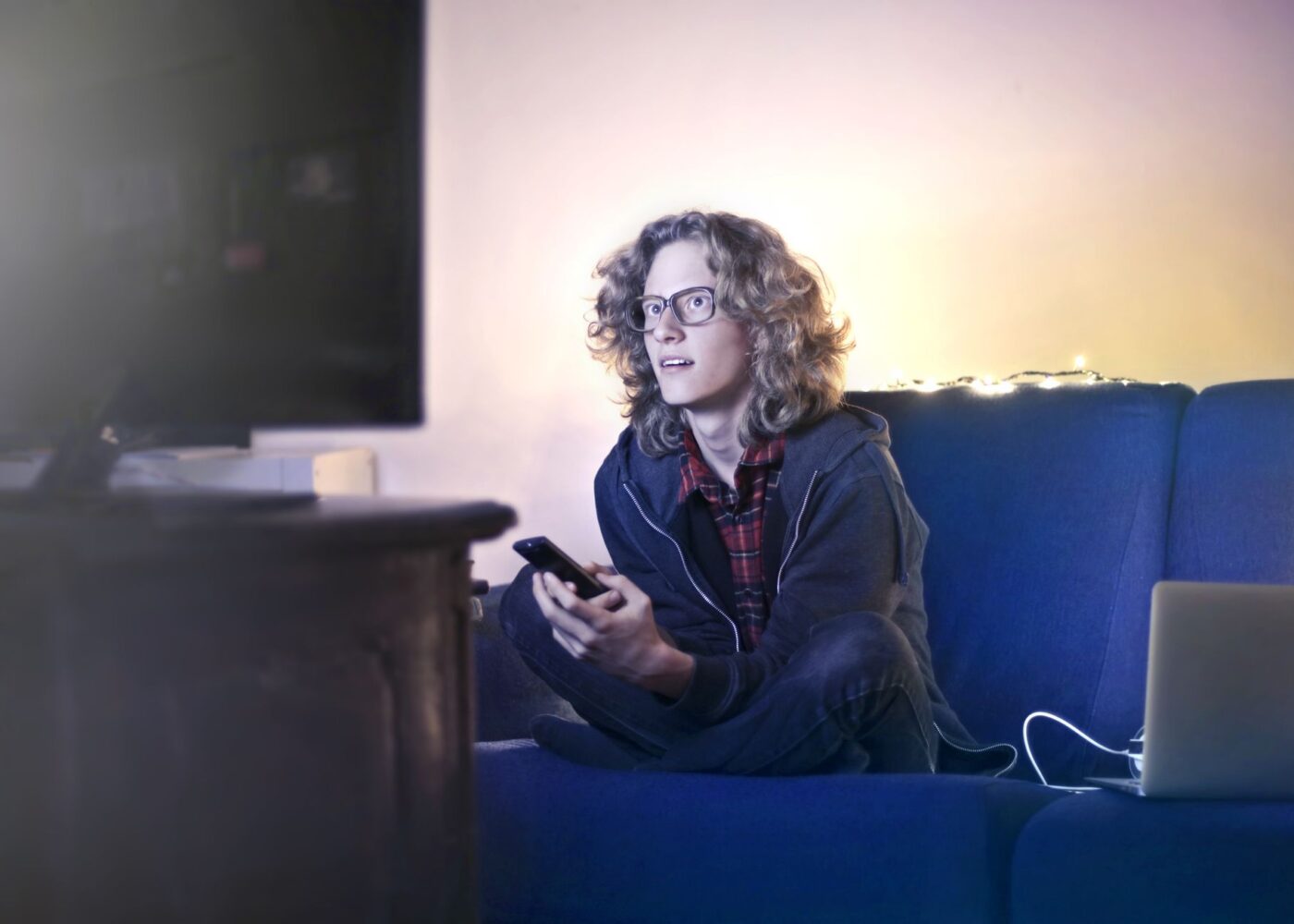 Woman on her couch reviewing streaming subscription charges during a spring subscription audit