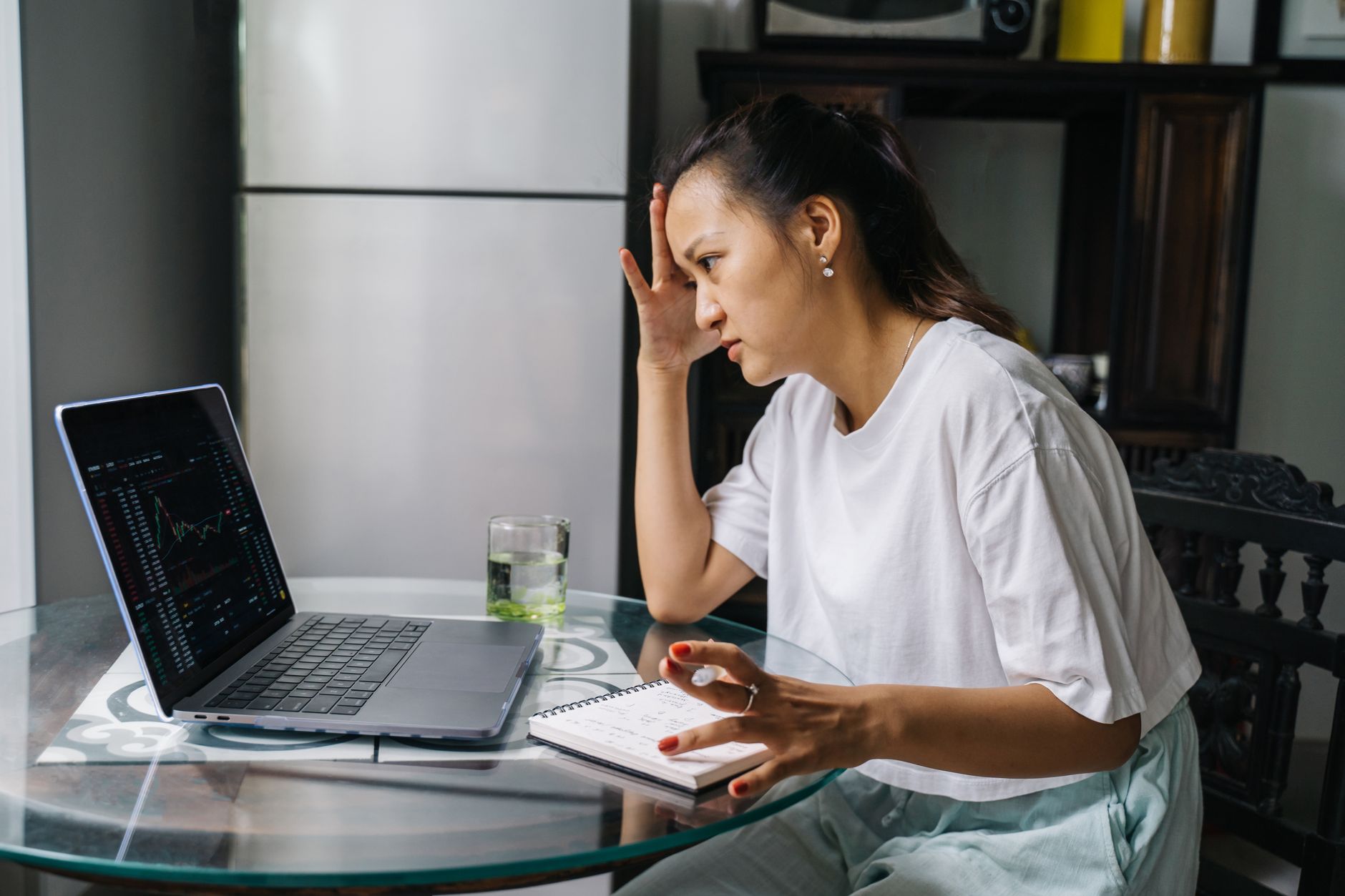 Woman checking her investment accounts on a laptop for automatic purchases