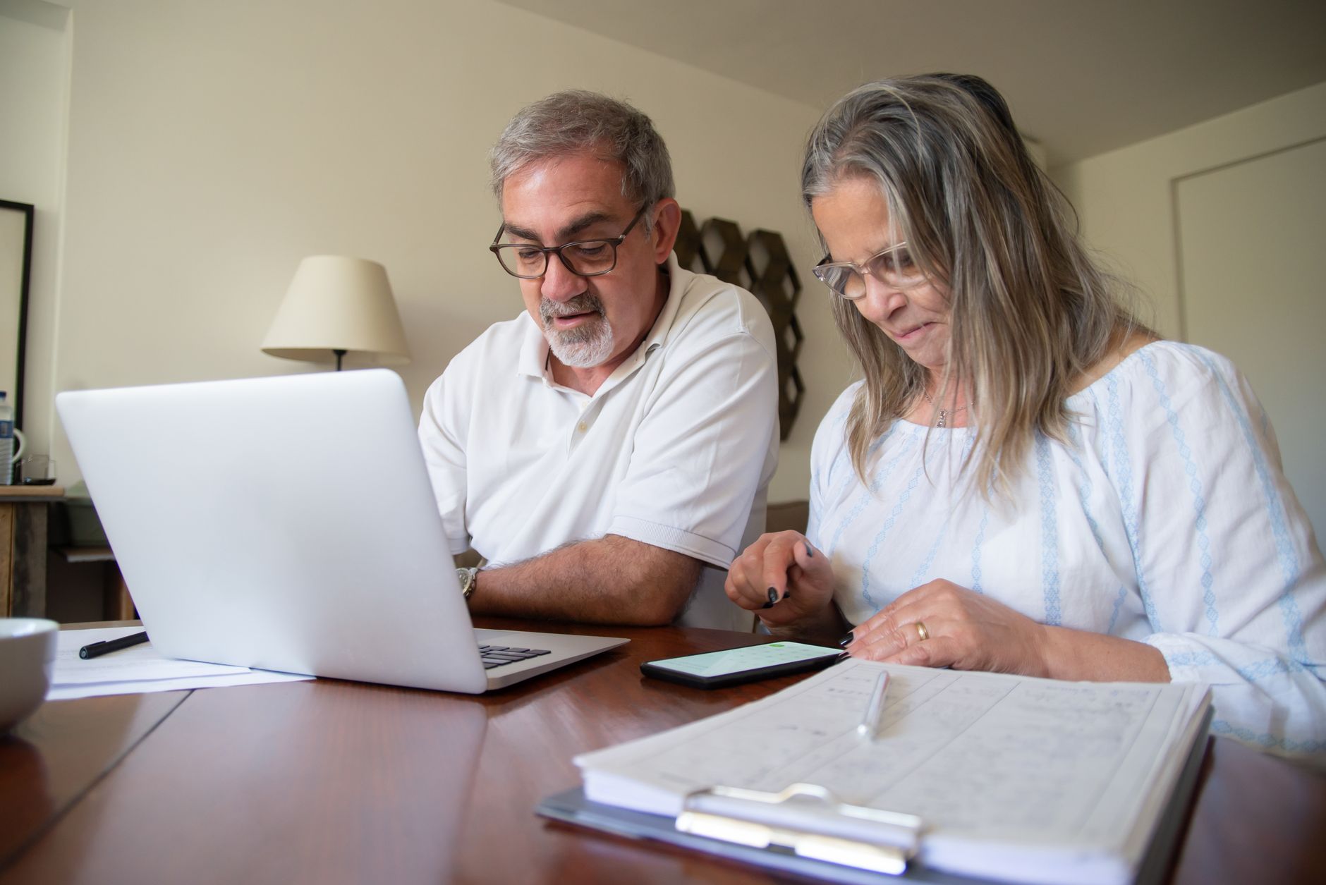 Couple reviewing brokerage and IRA statements together at home