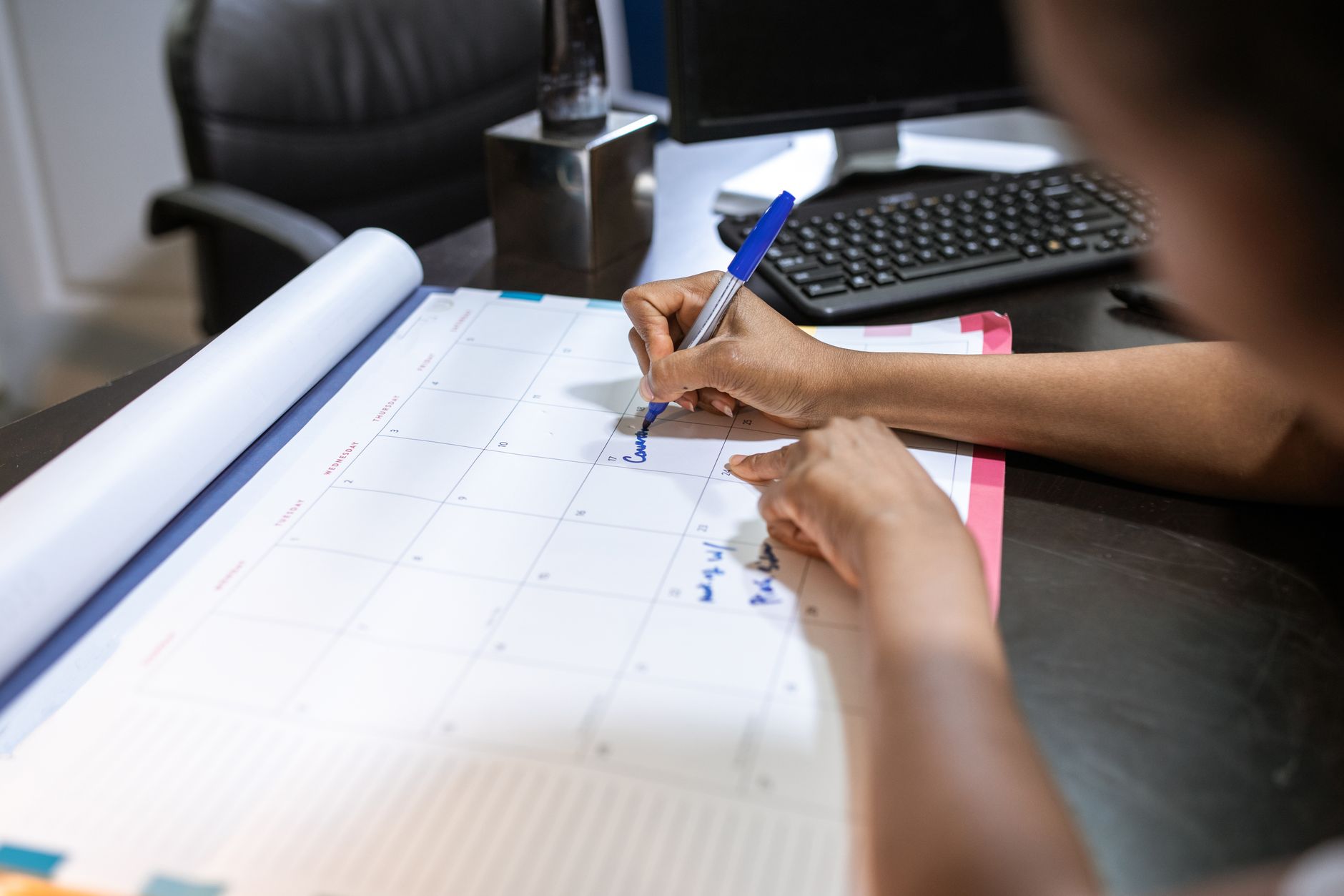 Woman mapping out a summer of wedding dates and costs in a planner