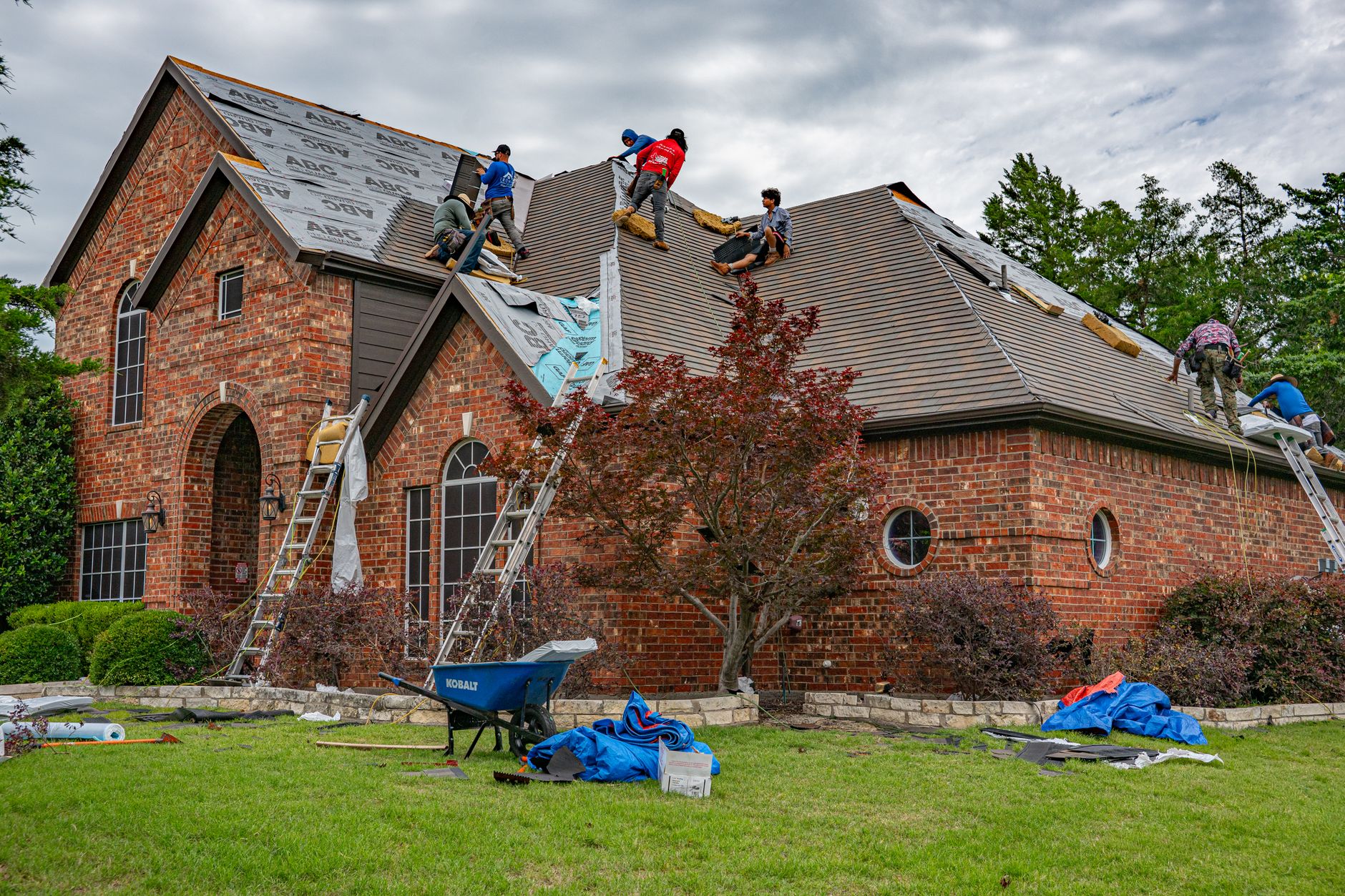 Roofer replacing damaged shingles, illustrating how an actual cash value roof settlement reduces a claim payout
